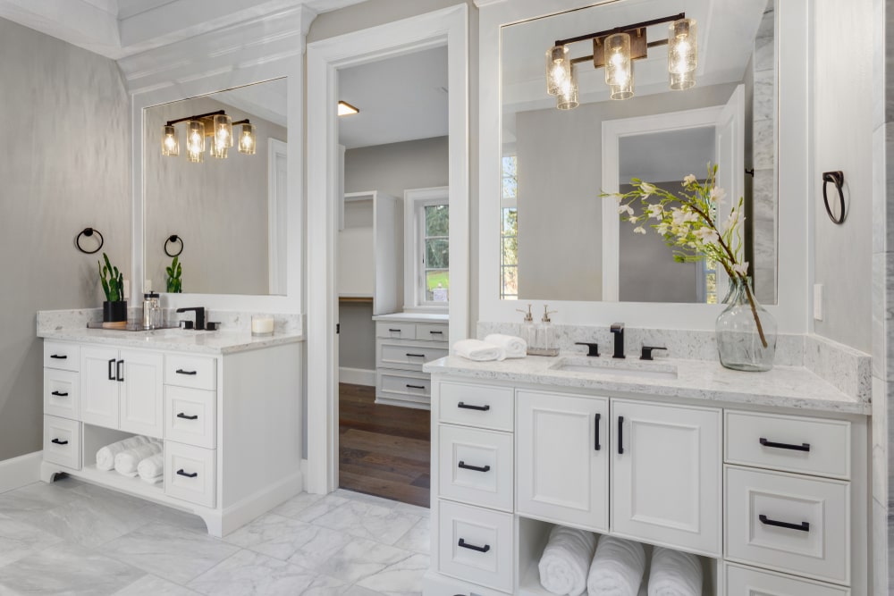 Double bathroom countertops with sink and light s with open door