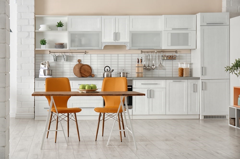 White Cabinetry and dinner table with orange chairs