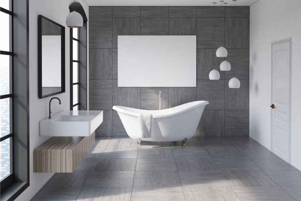 Bathroom with bathtub and floor tiles and white sink with rectangle mirror