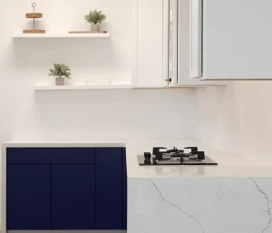 Oven on Marble countertop and dark navy cabinetry with decor at shelving
