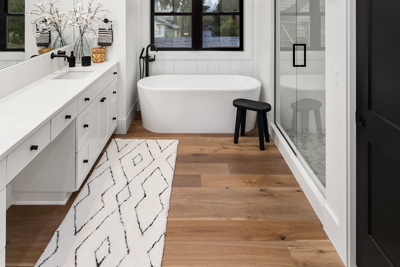 Bathroom on hardwood laminate flooring with white counter and carpet