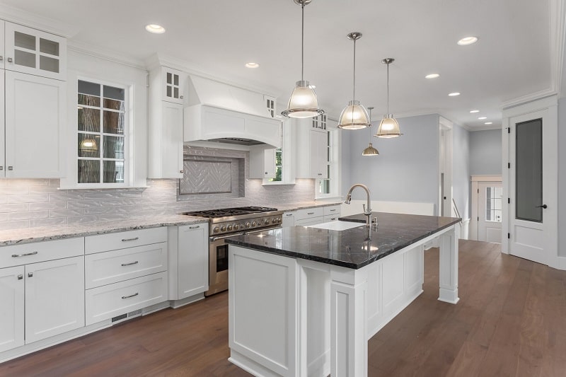 Kitchen with white themed cabinetry and countertop with ambient lighting