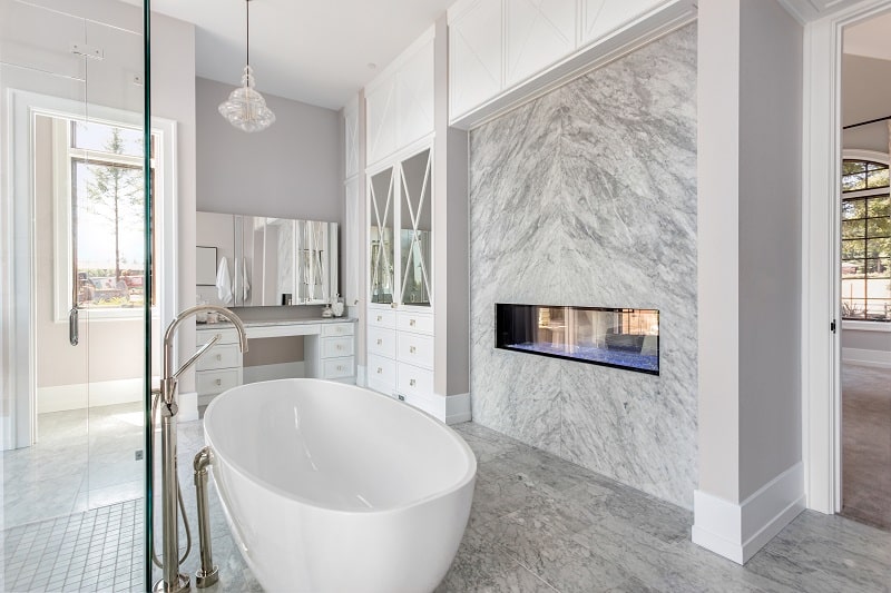 Elegant bathroom with fireplace and bathtub in new luxury home