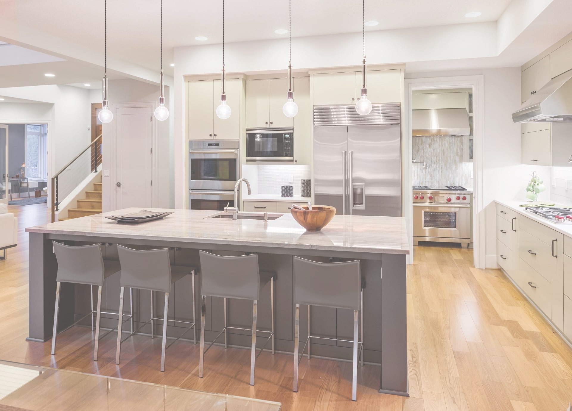 Kitchen Interior with Island, Sink, Cabinets, and Hardwood Floors in New Luxury Home