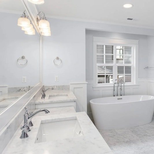 an empty bathroom with all white furniture and a tub