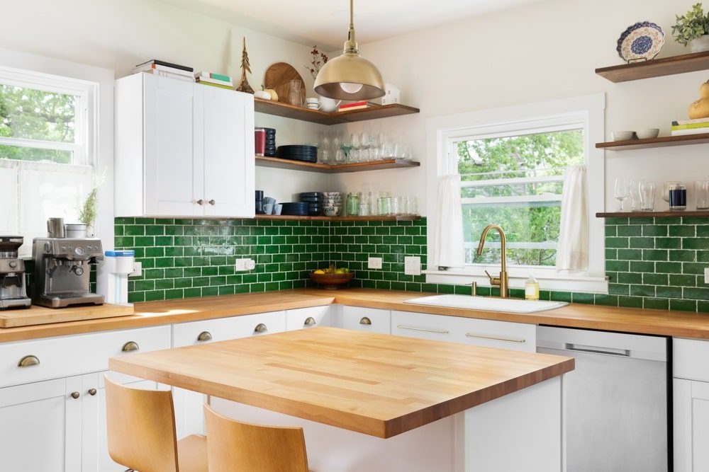A beautifully designed kitchen featuring a green tile backsplash.