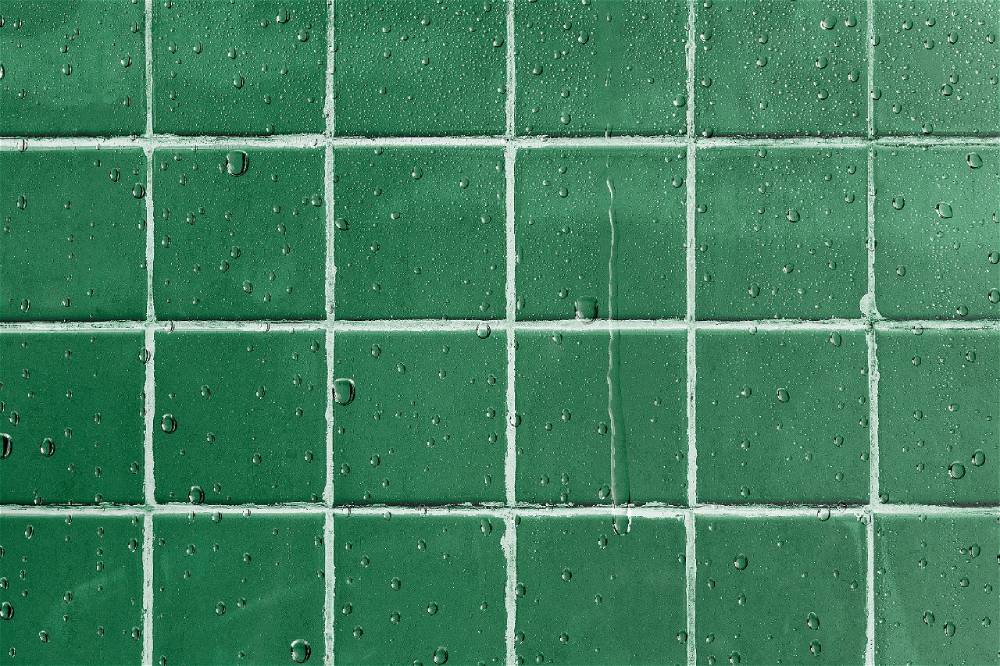 A beautifully designed kitchen featuring a green tile backsplash.