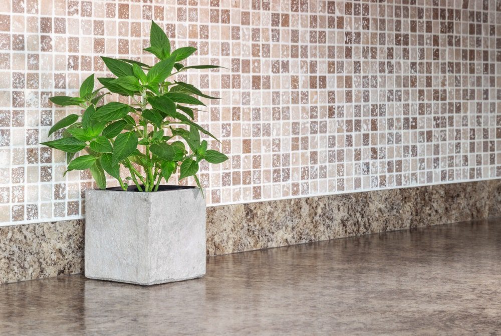 A beautifully designed kitchen featuring a green tile backsplash.