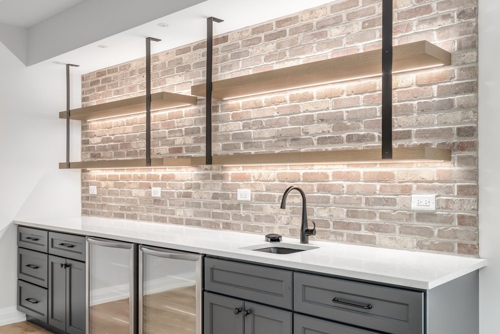 A modern kitchen with white cabinets and black hardware detailing.