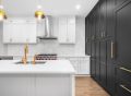 A modern kitchen with white cabinets and black hardware detailing.