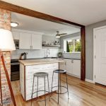 A small kitchen with a stylish kitchen island featuring built-in storage and seating.