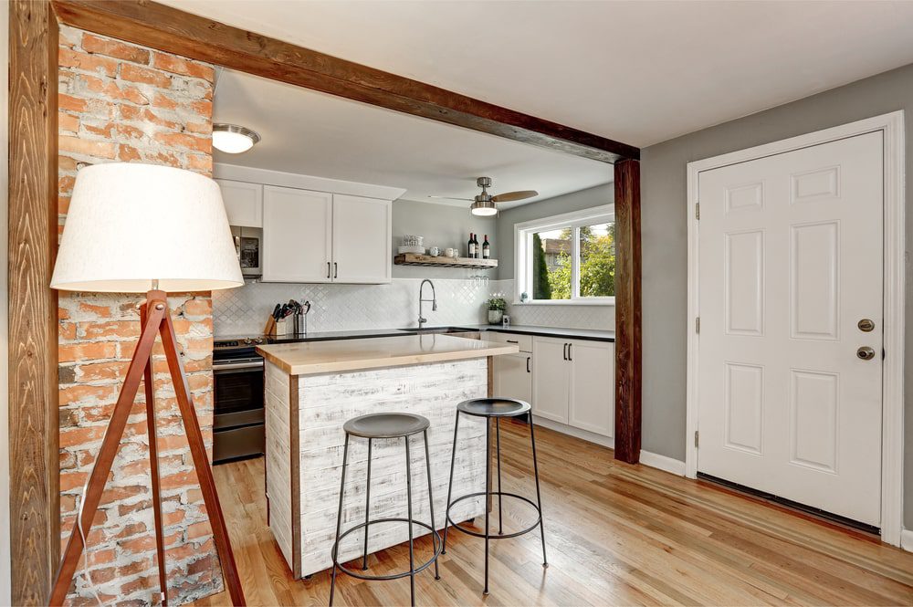 A small kitchen with a stylish kitchen island featuring built-in storage and seating.