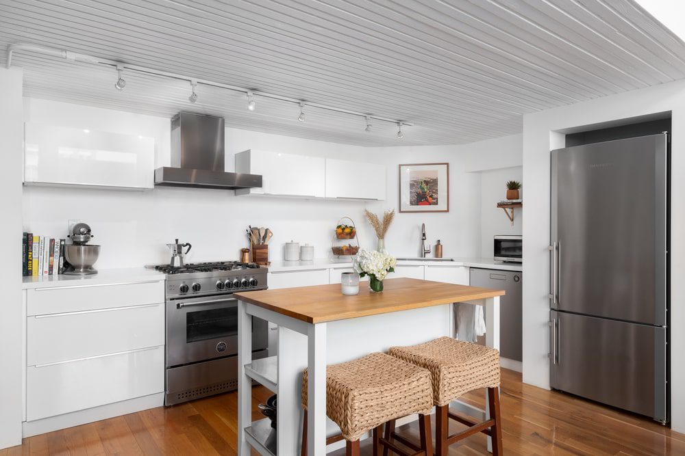 A small kitchen with a stylish kitchen island featuring built-in storage and seating.