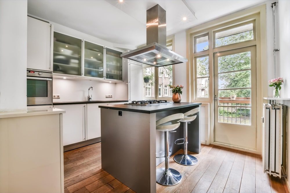 A small kitchen with a stylish kitchen island featuring built-in storage and seating.