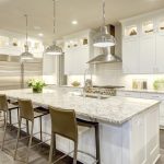 A modern kitchen remodel with sleek cabinets, a marble countertop, and stainless steel appliances.