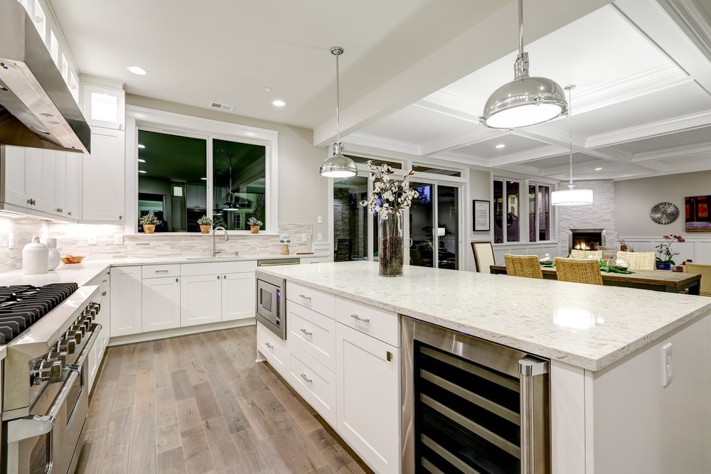 A modern kitchen remodel with sleek cabinets, a marble countertop, and stainless steel appliances.