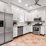 Modern kitchen under renovation, with cabinets removed and new appliances ready for installation.