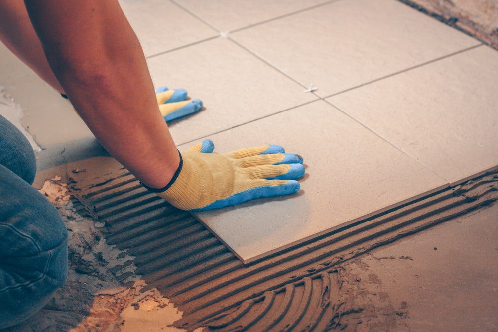 Tile installation with leveling clips, membrane, and trims laid out for a detailed flooring scope