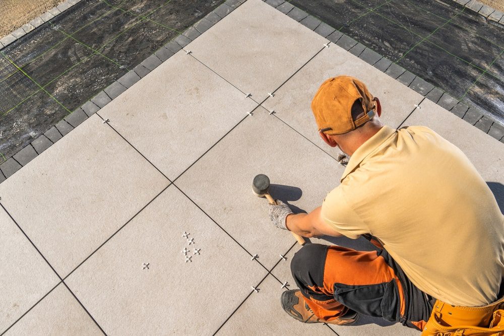 Tile installation with leveling clips, membrane, and trims laid out for a detailed flooring scope
