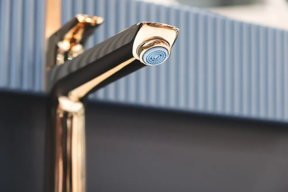 Person tightening a bathroom sink faucet during installation