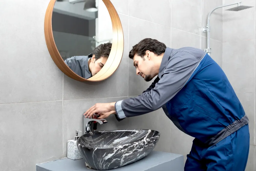 Contractor reviewing bathroom remodel plans and permit paperwork in a home renovation setting