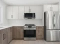 Kitchen with coordinated cabinets, tile flooring, quartz countertops, and warm modern lighting