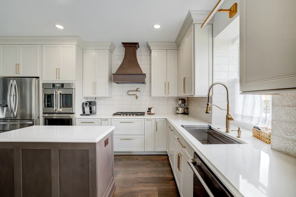 Kitchen with coordinated cabinets, tile flooring, quartz countertops, and warm modern lighting
