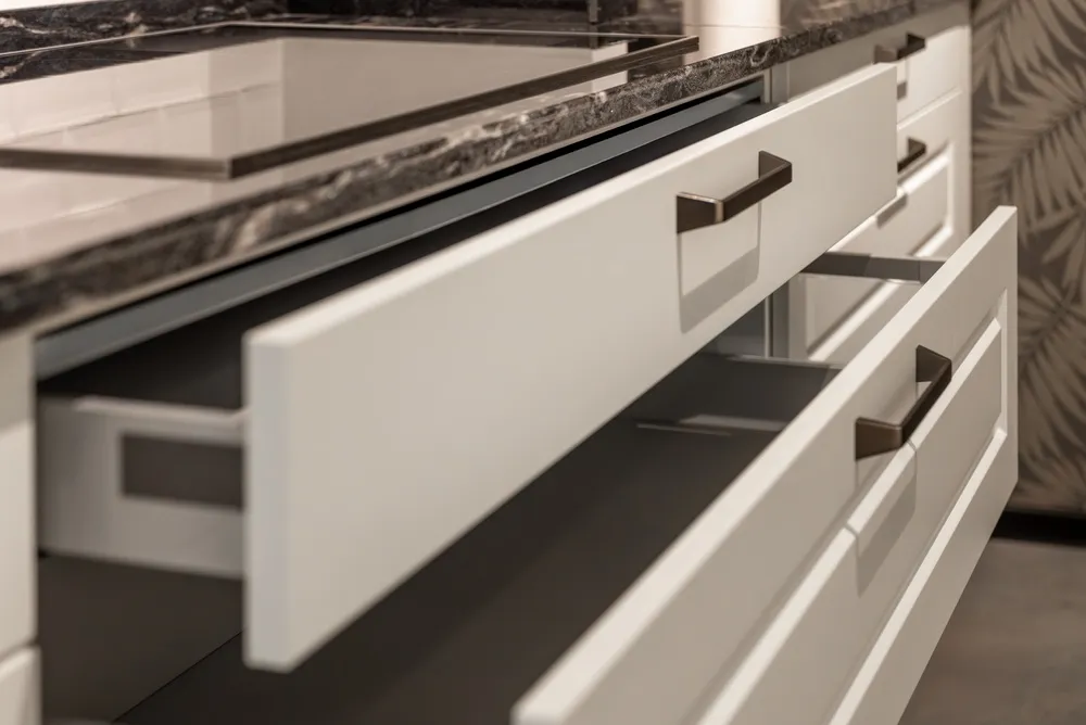 Kitchen with coordinated cabinets, tile flooring, quartz countertops, and warm modern lighting

